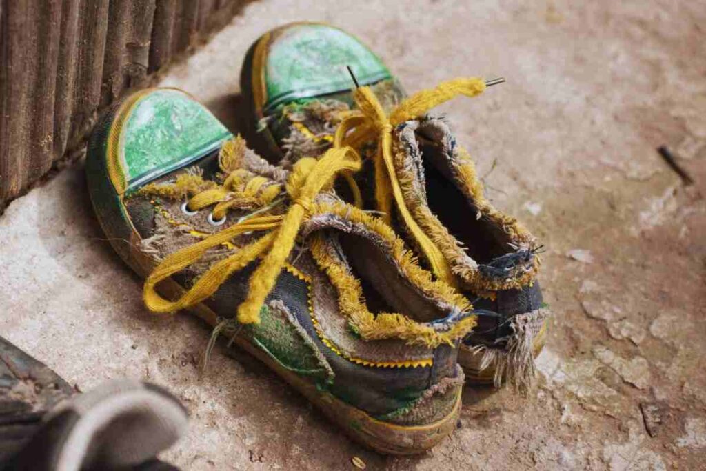 bambino con le scarpe rotte